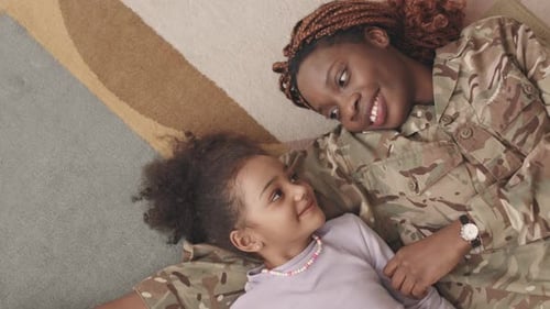 Military Mother and Daughter Cuddle on Rug