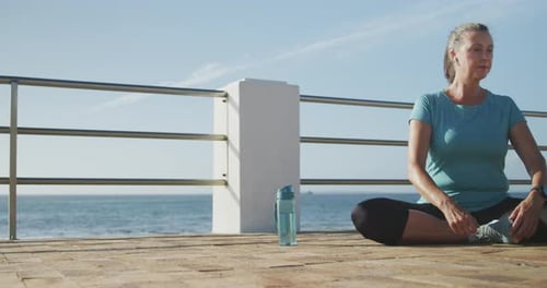 Senior woman stretching her legs on a promenade