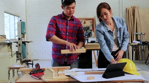 Woodworkers Inspecting Plans in a Workshop