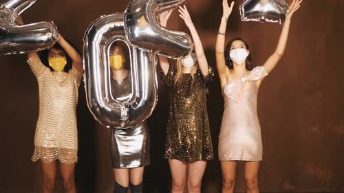 Four Women Celebrate With 2021 Balloons and Masks