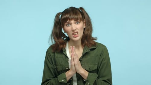 Young Woman Pleads with Hands Clasped Begging