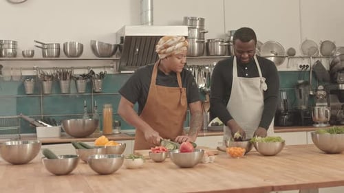 Chefs Chopping Vegetables Together in Kitchen