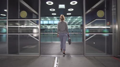 Female Passenger Traveler Checking Information of Boarding Pass Ticket and on Schedule Board