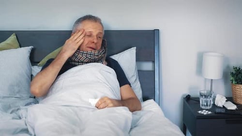 Man with a cold lying in bed