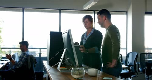 Colleagues Discussing Computer Screen in Modern Office