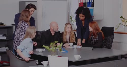 Team Discussing Tablet at Corporate Office Meeting