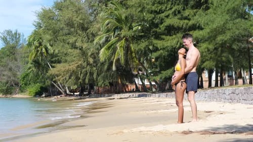 Romantic Young Couple Standing Under the Sun in the Calm and Exotic Beach