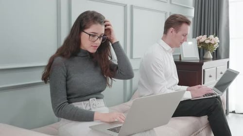 Man and Woman Working on Laptops Together