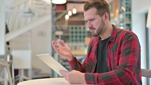 Loss on Tablet for Disappointed Young Man in Cafe