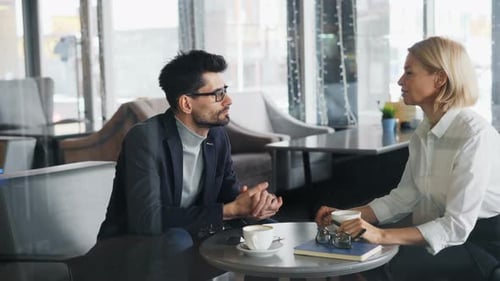 Mature Businesspeople in Formalwear Talking in Cafe During Business Lunch