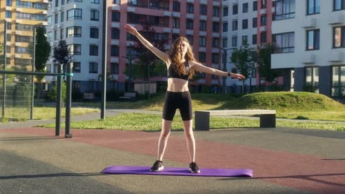 Woman Stretching on Yoga Mat in City Setting