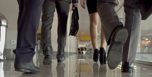 Group of Businesspeople Walking in Bright Hallway