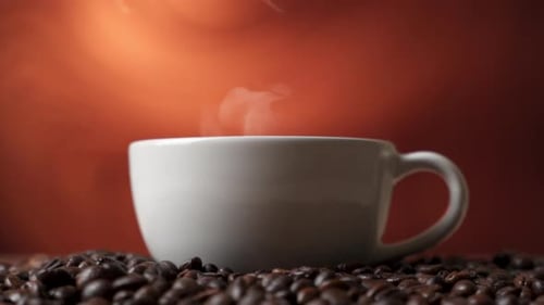 Side View of White Cup of Black Coffe on Coffee Beans