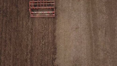 a Large Tractor Plows a Field