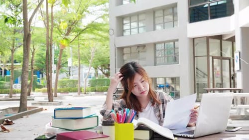 Asian student studying in work space in college. A high school student writes an essay