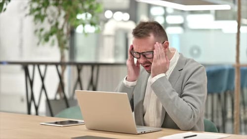 Stressed Man Working on Laptop in Office