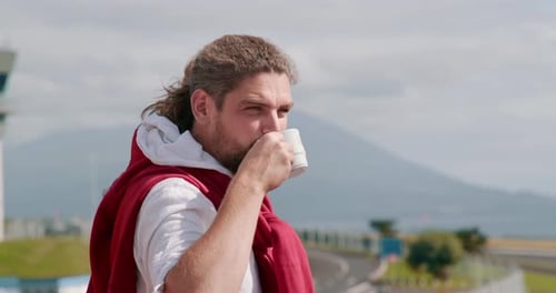 Man Drinking Coffee Outdoors on Sunny Day