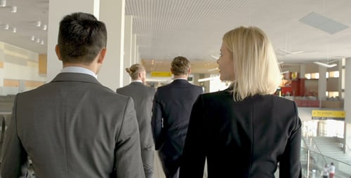 Business Team Walking Through Airport Terminal