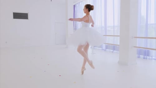 Elegant Ballerina Dancing in White Dance Studio
