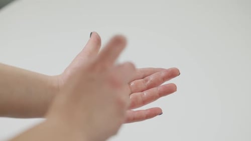 Woman Applies Hand Sanitizer with Multicolored Nail Polish