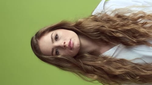 Pretty Girl With Long Hair Stands Near The Wall