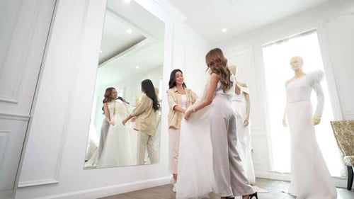 4K Asian woman lesbian couple trying on wedding dress in front of the mirror together at bridal shop 4K Asian woman lesbian couple trying on wedding dress in front of the mirror together at bridal shop