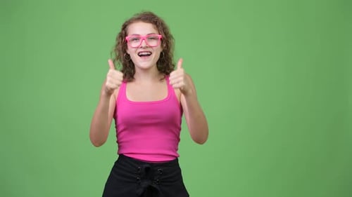 Young Woman Giving Thumbs Up on Green Background