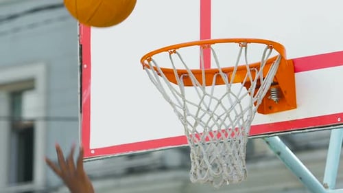 Afroamerikanischer Athlet wirft Ball in den Korb und bringt seinem Team den Sieg
