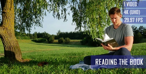 Gesunder Kerl liest ein Buch unter dem Baum