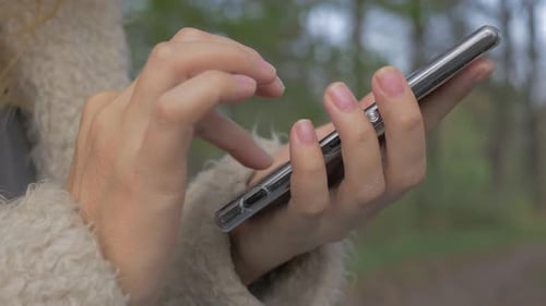 Woman Using Smartphone Outdoors Close Up