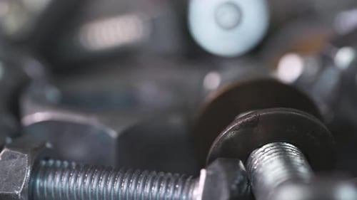 Slider Shot-Video von Chromschrauben und Muttern in einem chaotischen industriellen Hintergrund