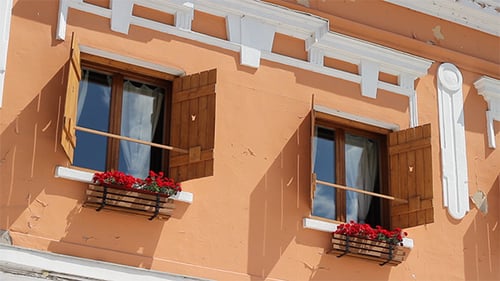 Facade of Building with Open Shutters and Flowers