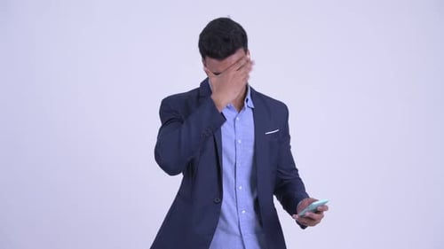 Man in Suit Using Phone with Disapproval