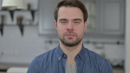 Man Stares at Camera Indoors Close Up