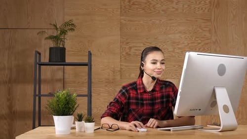 Woman Working At Desk Wearing Headset