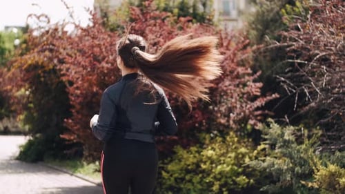 Woman Running in Park on Sunny Day