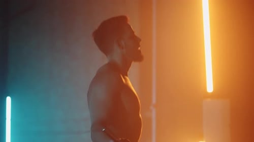 A Muscular Man Without a Tshirt with a Naked Torso Jumps on a Rope in Slow Motion