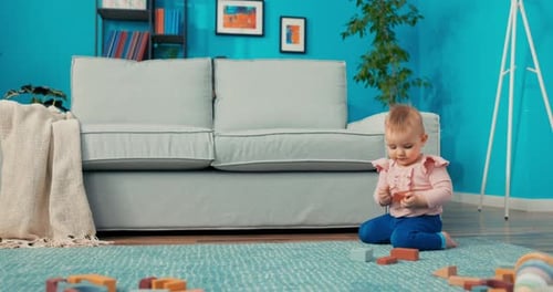 Infant Playing with Wooden Blocks on Rug