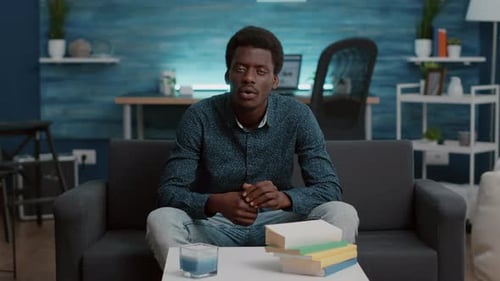 Young Adult Man Sitting on Couch Talking