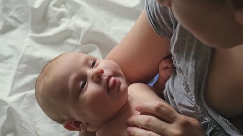 Close Up of Newborn Baby Dreaming on Mothers Chest