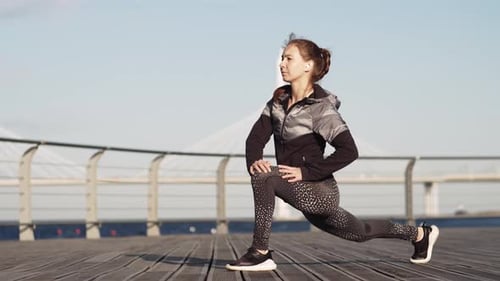 Woman Stretching Leg Muscles on Boardwalk Outdoors