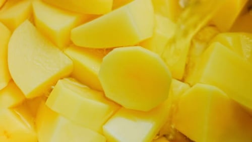 O cozinheiro derrama água de uma tigela sobre as batatas cozidas