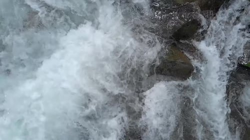 Das Wasser des stürmischen Gebirgsflusses fließt zwischen Steinen
