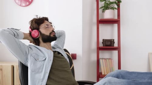 Man Relaxing in Chair Listening to Music