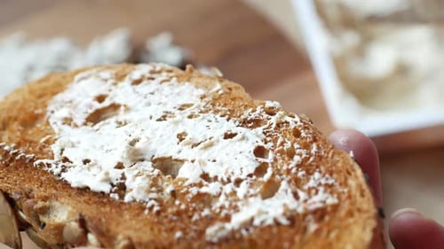 Creamy Cheese Being Spread on Toast