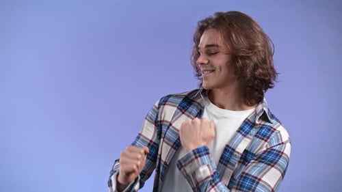 Hipster Man Dancing Positive on Violet Studio Background