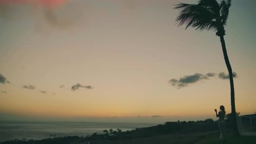 Woman With Mobile Phone at Tropical Ocean Sunset