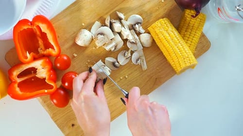 Top View Close-up of a Young Woman Cutting Vegetables in the Kitchen