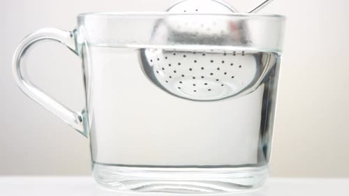Transparent Cup with Tea in White Studio Space. Minimalistic Video Brewing Tea