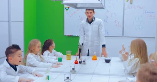 Enthusiastic Students Observe Science Teacher Explaining Experiment